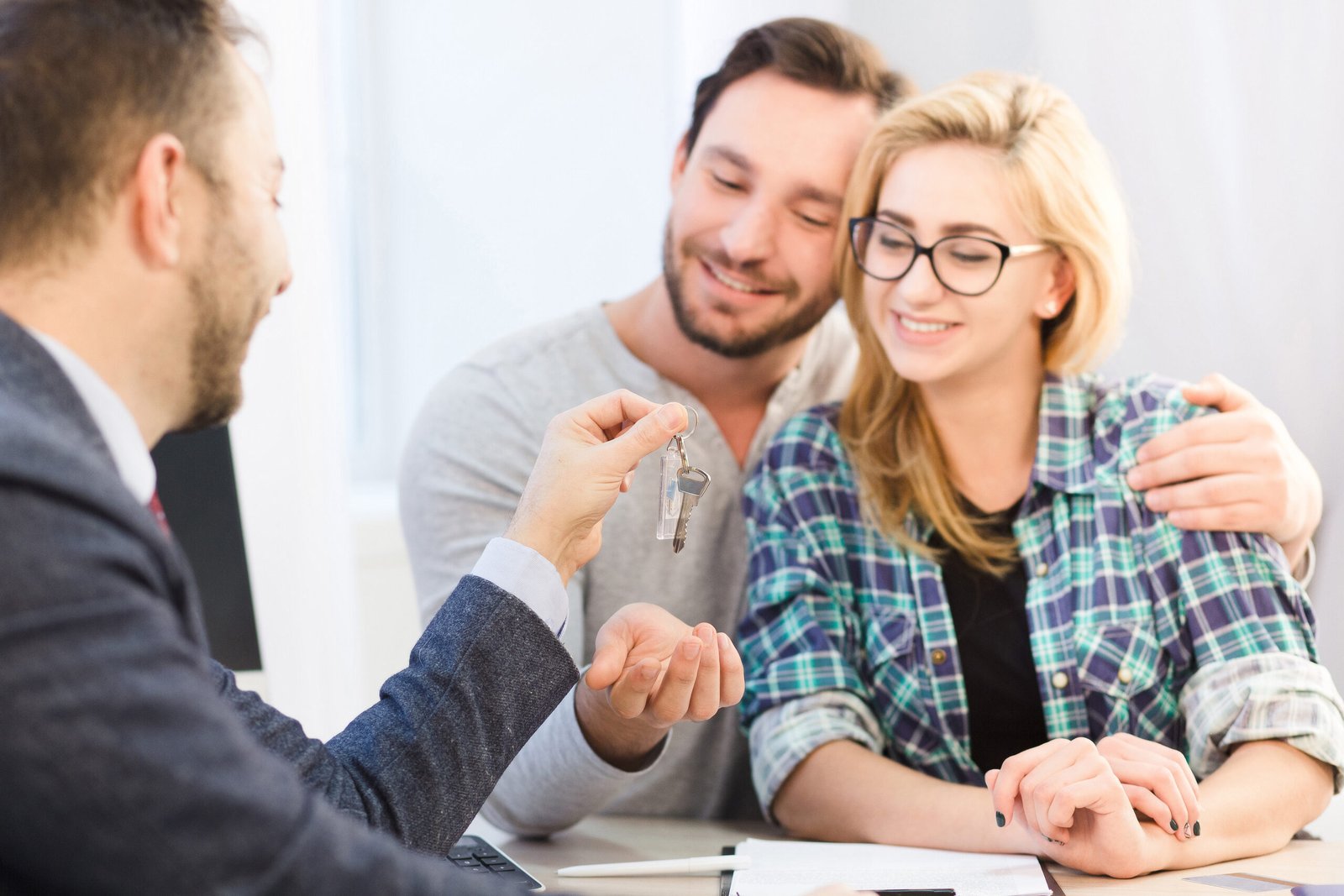Casal conversa com uma consultora imobiliária durante a procura por um imóvel na Itália.